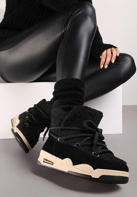 Botas negras de invierno para mujer con suela beige y cordones gruesos estilo urbano.