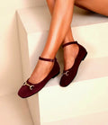 Bailarinas burdeos para mujer con pulsera al tobillo y detalle metálico frontal, diseño elegante y cómodo.